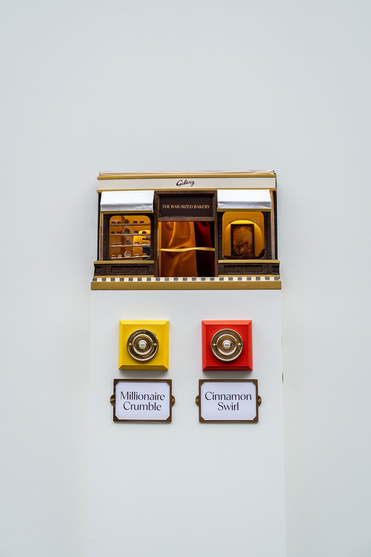 The Bar-Sized Bakery on its stand, with a yellow bell for Millionaire Crumble and a red bell for Cinnamon Swirl