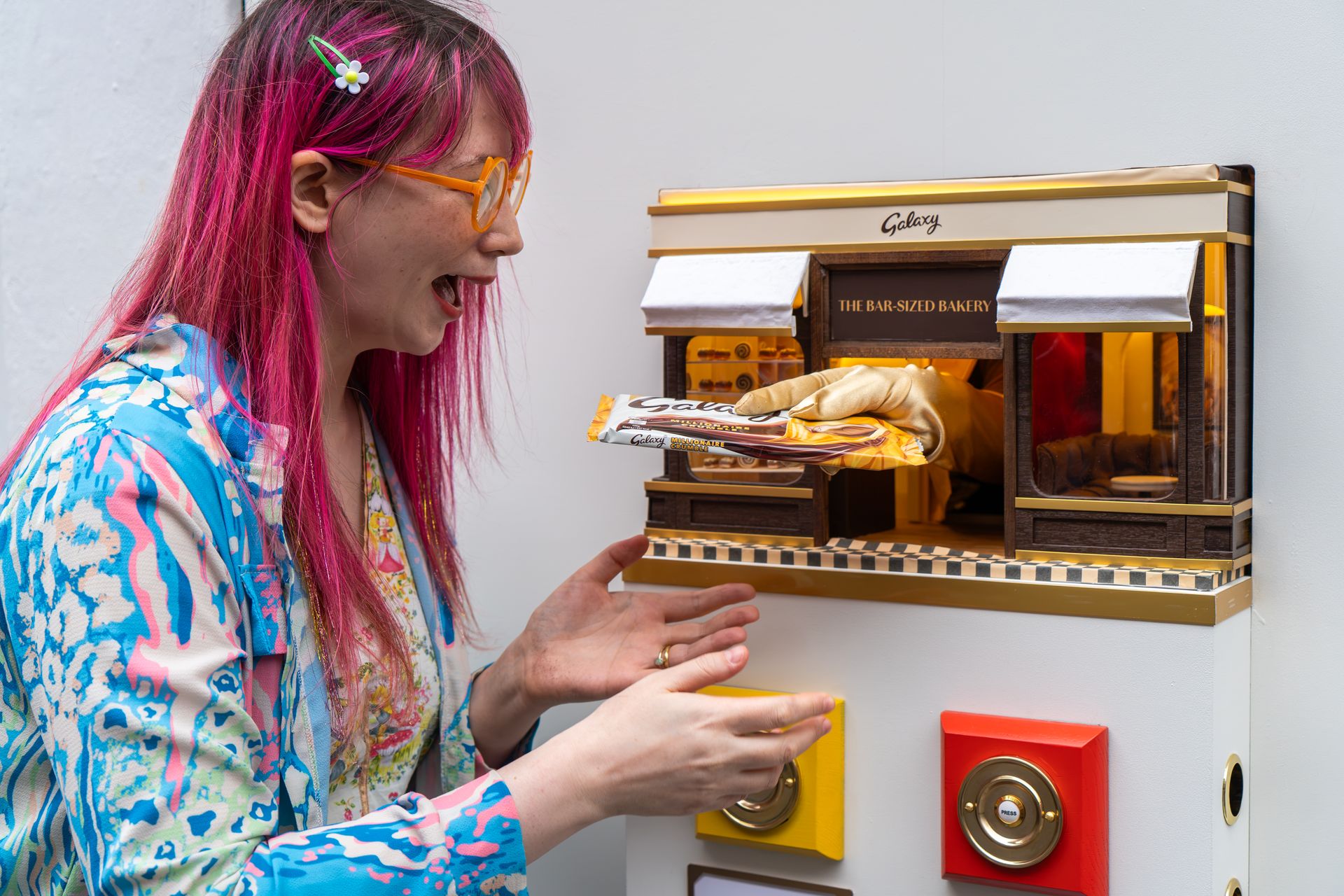 Kim-Joy laughing as a Galaxy bar comes out of the miniature bakery